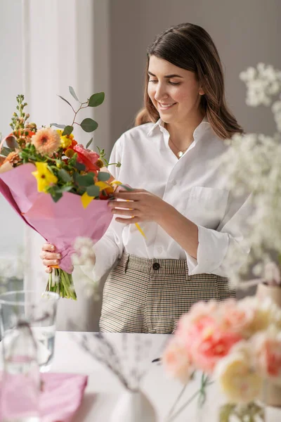 Ευτυχισμένη γυναίκα με λουλούδια στο σπίτι. — Φωτογραφία Αρχείου
