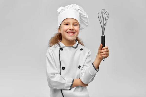 Smiling little girl in chefs toque with whisk — Stock Photo, Image
