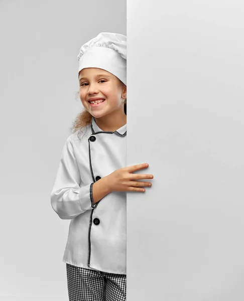 Menina feliz em chefs toque com placa branca — Fotografia de Stock