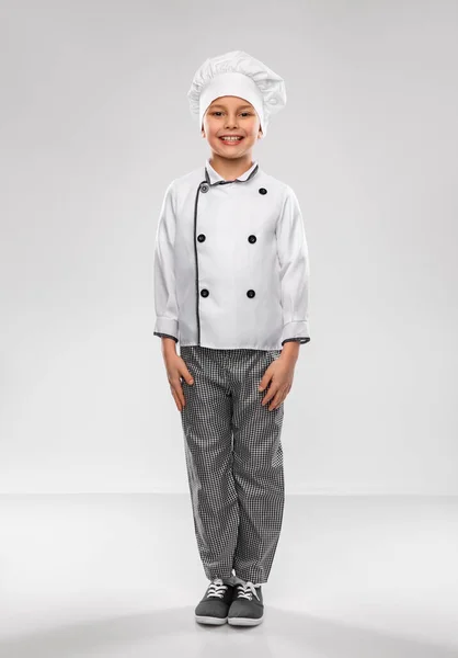 Garotinho sorridente em chefs toque e jaqueta — Fotografia de Stock