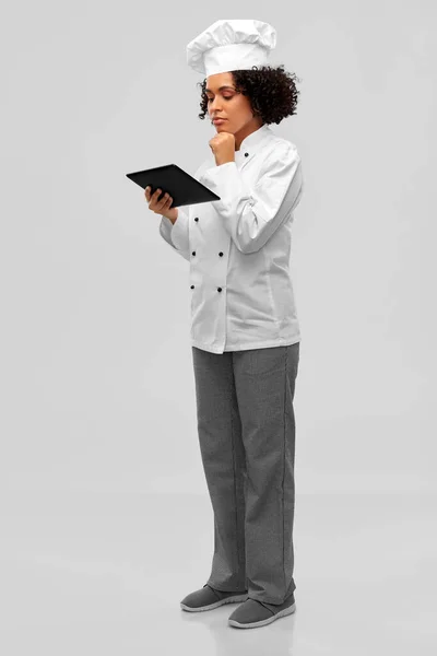 Thinking female chef with tablet computer — Stock Photo, Image