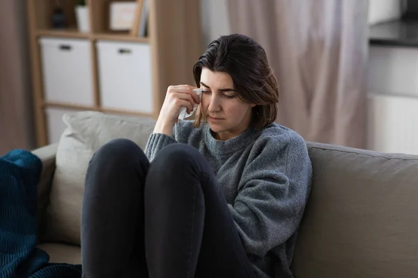 Triste llorando mujer sentado en sofá en casa —  Fotos de Stock