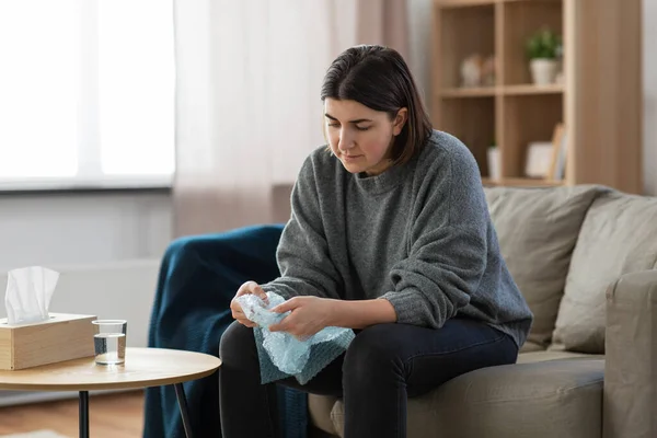 Sad woman popping bubble wrap at home — ストック写真