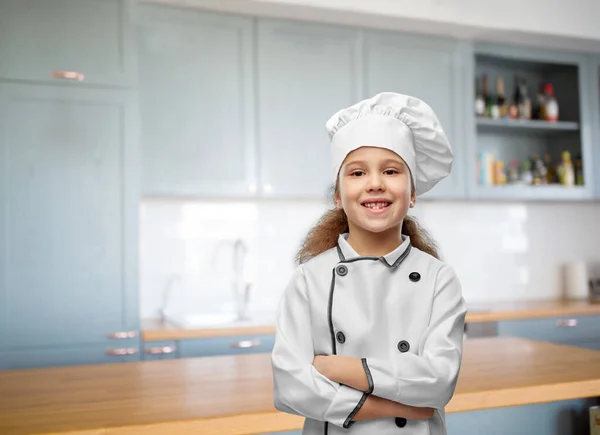 Mosolygós kislány szakácsok toque a konyhában — Stock Fotó