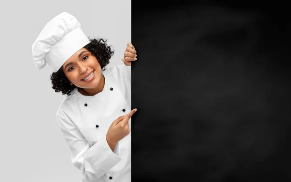 Usmívající se fena kuchařka s černou tabulí — Stock fotografie