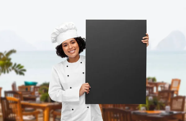 黒人の黒板を持った笑顔の女性シェフ — ストック写真