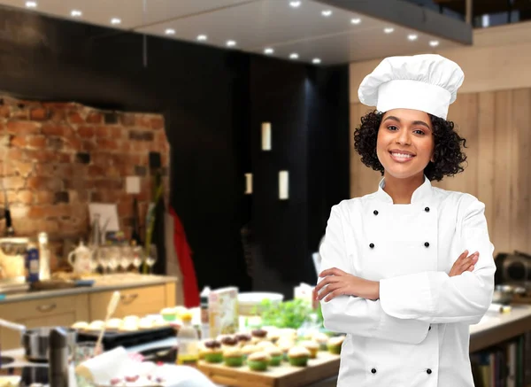 Leende kvinnlig kock i toque på restaurang — Stockfoto