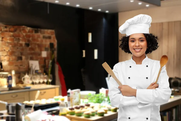 Chef femenino sonriente con cuchara de madera y espátula — Foto de Stock