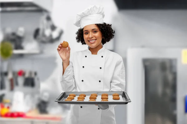 Chef feminino feliz com biscoitos na bandeja do forno — Fotografia de Stock