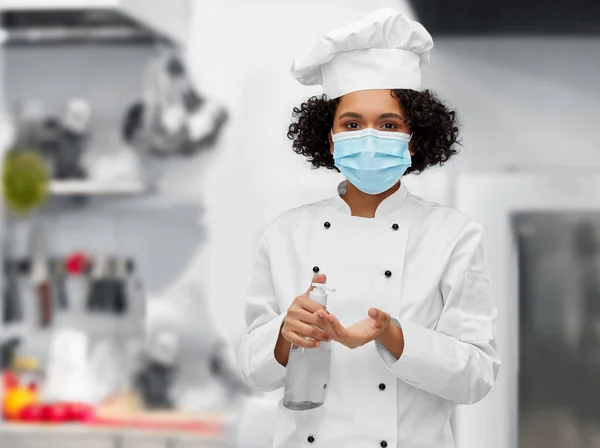 Vrouwelijke chef-kok in masker met handreiniger of zeep — Stockfoto