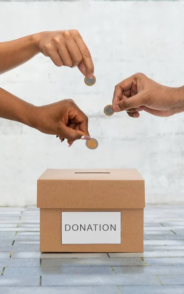 Hands putting coins into donation box on street — ストック写真