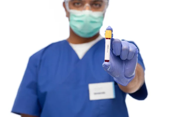 Médico masculino mascarado com sangue no tubo de ensaio — Fotografia de Stock