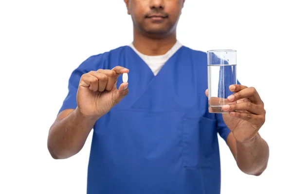 Doctor or male nurse with medicine pill and water — Stok fotoğraf