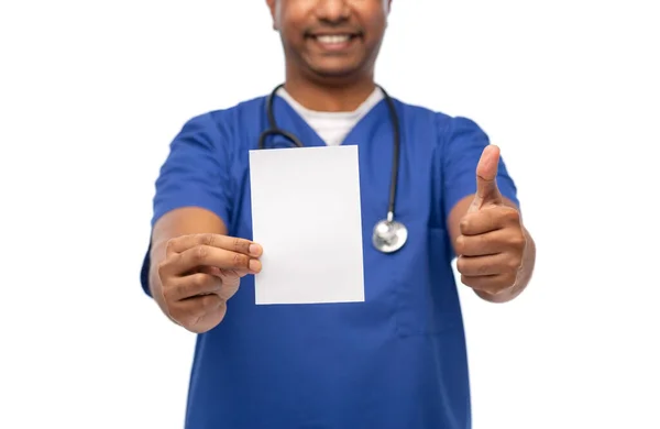 Усміхнений лікар або медсестра чоловічої статі, що показує білий папір — стокове фото