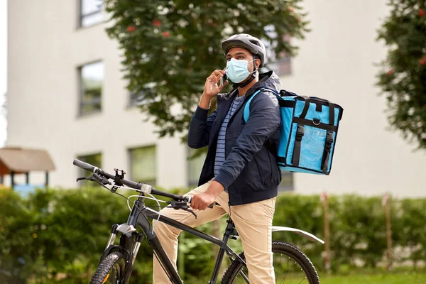 Dodávka muž v masce s smatphone jízda na kole — Stock fotografie