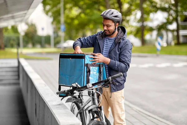 Hombre con bolsa de comida y bicicleta en la ciudad —  Fotos de Stock