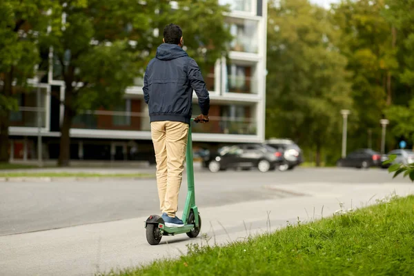 Mann som kjører elektrisk scooter i byen – stockfoto