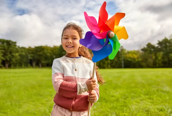 Happy girl with pinwheel at summer park — Stok fotoğraf