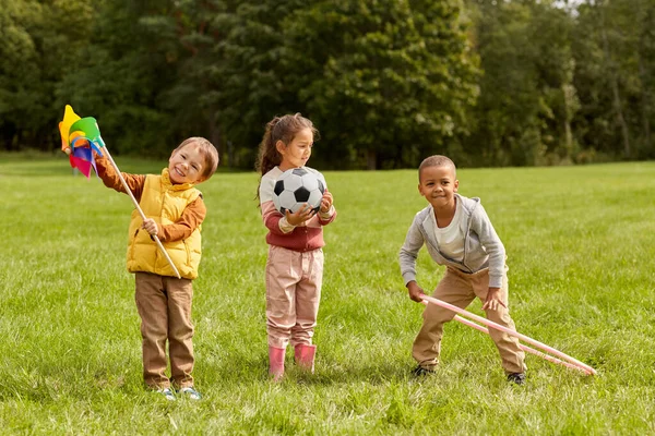 Happy kids with pinwheel having fun at park — Stock Photo, Image