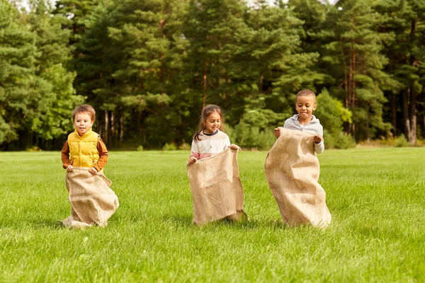 Gelukkige kinderen spelen tas springen spel in park — Stockfoto