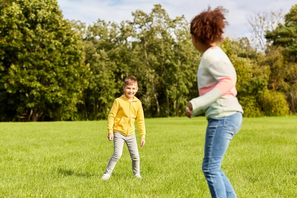 Glückliche Kinder spielen und rennen im Park — Stockfoto