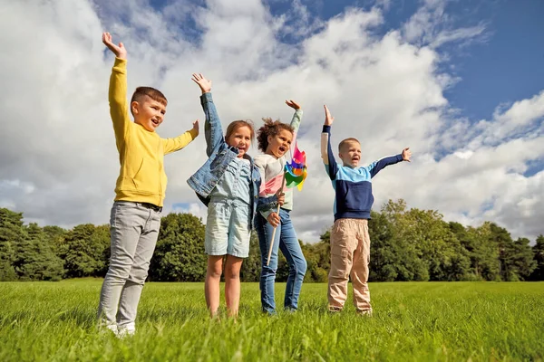 公園で楽しいピンホイールを持つ幸せな子供たち — ストック写真