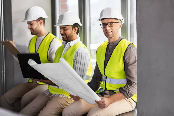 Arquitectos masculinos en cascos trabajando en la oficina —  Fotos de Stock