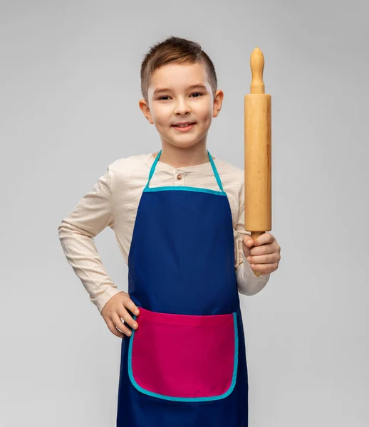 Lächelnder kleiner Junge in Schürze mit Nudelholz — Stockfoto