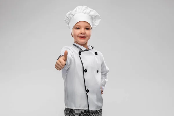 Bambina in chefs toque mostrando pollici in su — Foto Stock