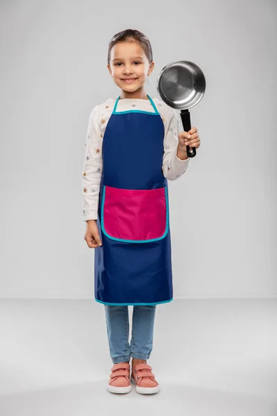 Little girl in apron with saucepan — Stock fotografie