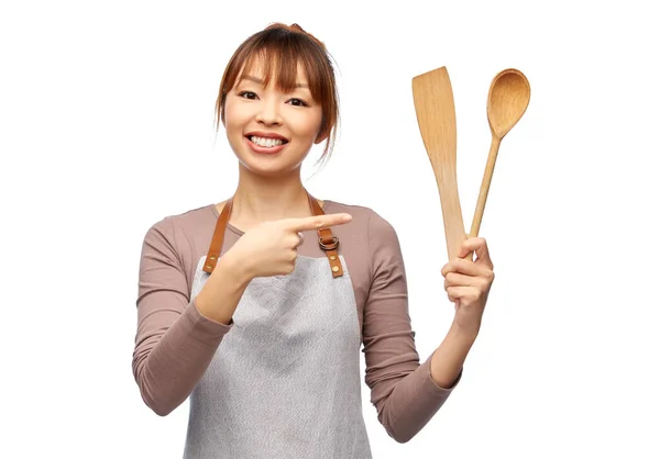 Femme heureuse dans tablier avec cuillère en bois et spatule — Photo