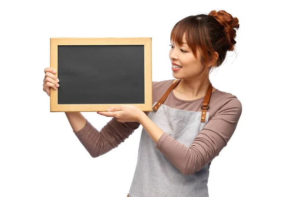 Glückliche Frau in Schürze mit Kreidetafel — Stockfoto