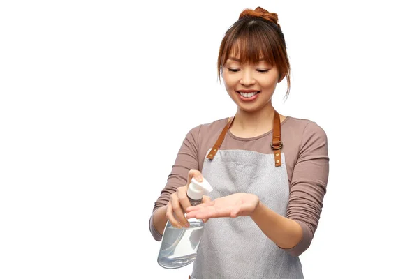 Mulher feliz em avental com higienizador de mão ou sabão — Fotografia de Stock