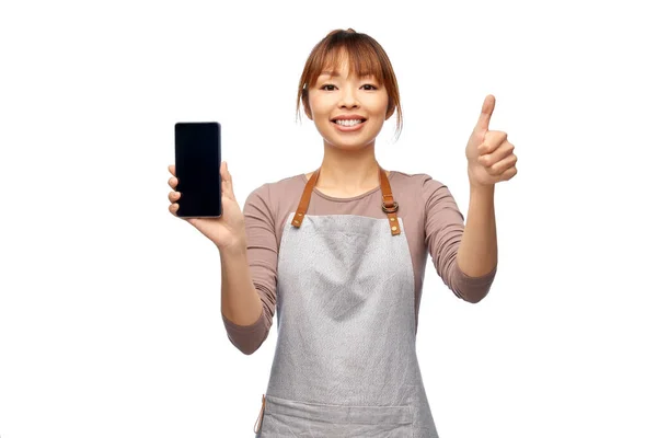 Mujer feliz en delantal mostrando teléfono inteligente — Foto de Stock