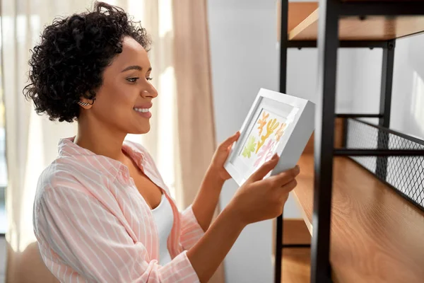 Gelukkig vrouw houden foto in frame thuis — Stockfoto