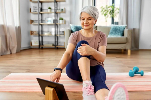 Mujer feliz con la tableta de ejercicios de PC en casa — Foto de Stock