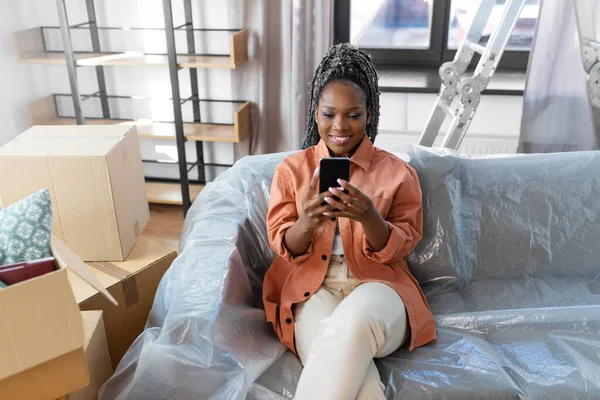 Vrouw met smartphone en dozen verhuizen naar nieuw huis — Stockfoto