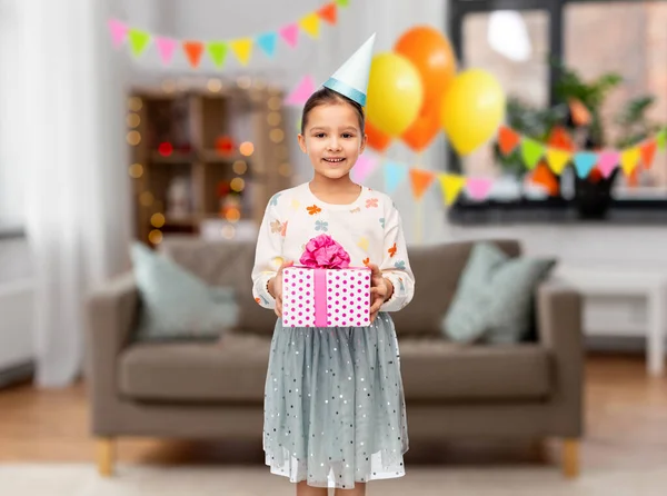 Lächelndes Mädchen im Partyhut mit Geburtstagsgeschenk — Stockfoto