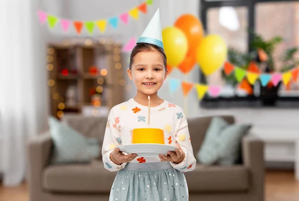 Menina sorridente em chapéu de festa com bolo de aniversário — Fotografia de Stock