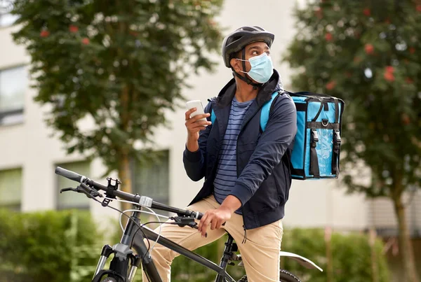 Dodávka muž v masce s smatphone jízda na kole — Stock fotografie