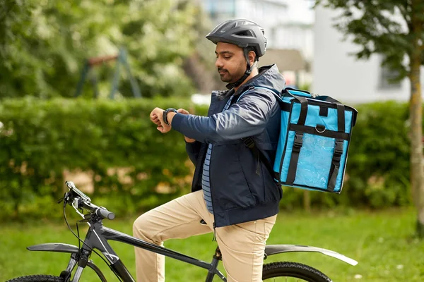 Доставки їжі чоловік з сумкою і велосипедом в місті — стокове фото