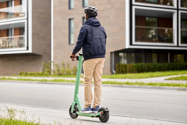 Mann mit Helm fährt Elektroroller auf Straße — Stockfoto