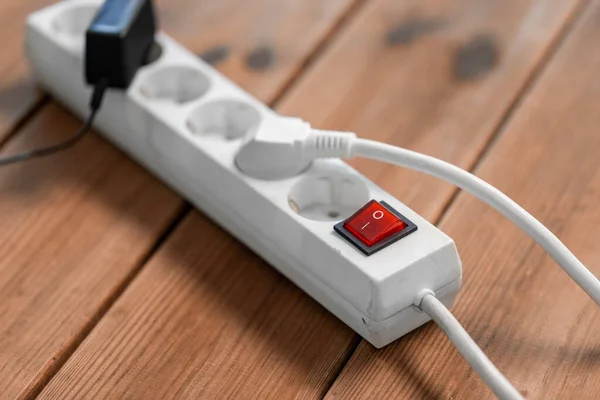 close up of socket with plugs and charger on floor