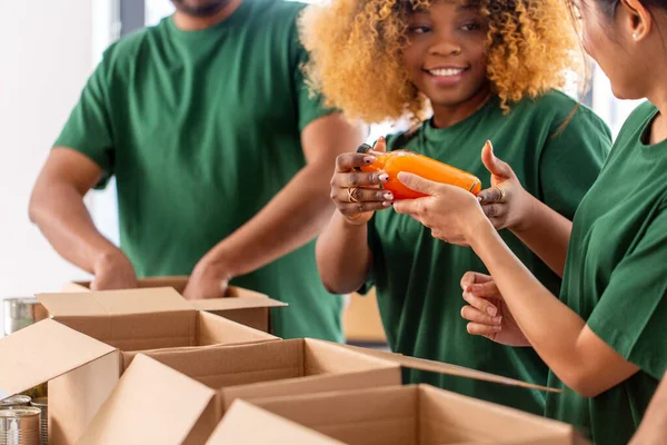 close up of volunteers packing food in boxes