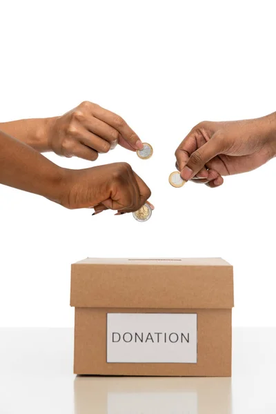 Close up of hands putting coins into donation box — ストック写真