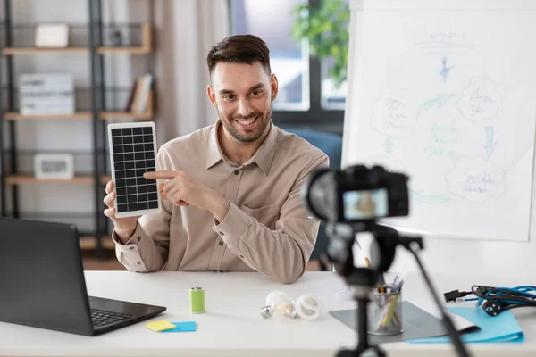 Male teacher with camera and solar battery at home — стоковое фото