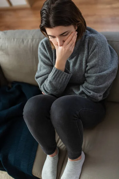 Mulher estressada sentada no sofá em casa — Fotografia de Stock