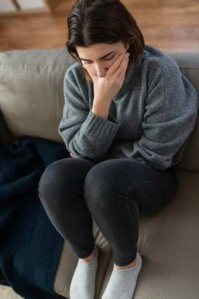 Gestresste Frau sitzt zu Hause auf Sofa — Stockfoto