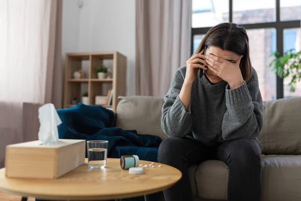 Stressed woman with medicine calling on phone — ストック写真