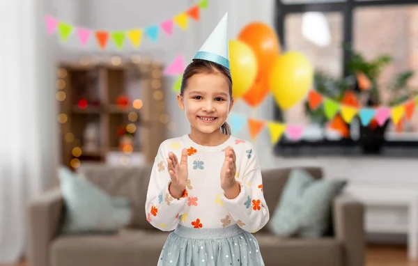 Boldog kislány születésnapi party kalap tapsol Jogdíjmentes Stock Képek